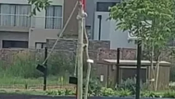 Graban a nene fantasma hamacándose en una plaza